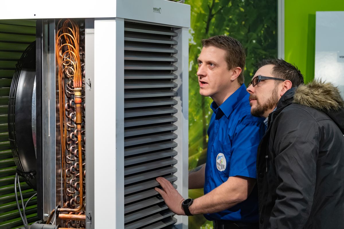 Zwei Männer begutachten ein Modell einer Wärmepumpe