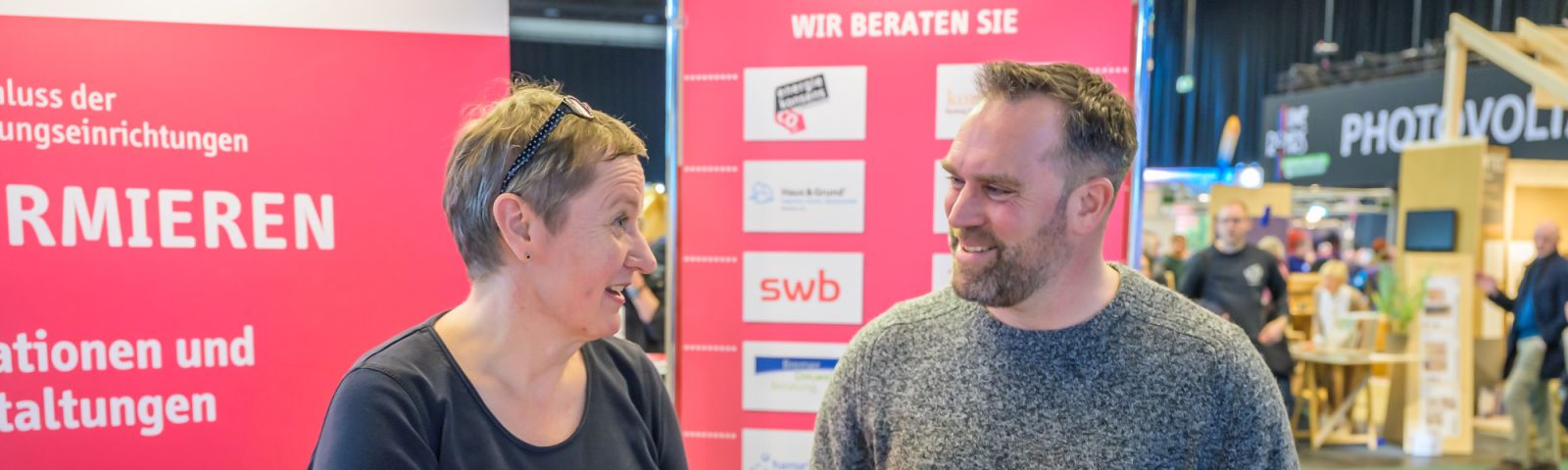 Frau am Stand Bremer Modernisieren berät Messebesucher