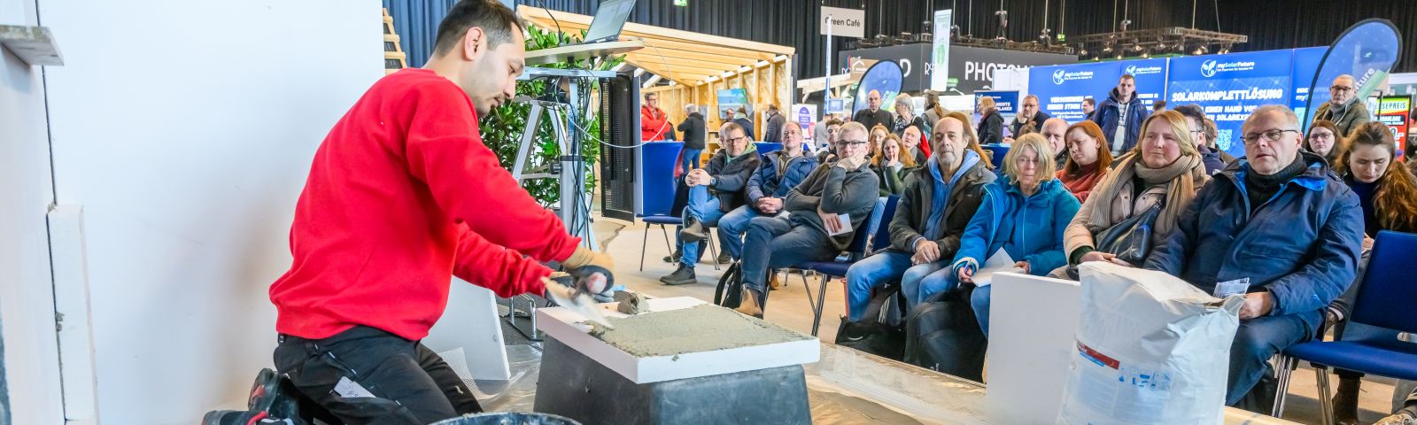 Mann führt Innenausbau auf der Bühne vor Publikum vor